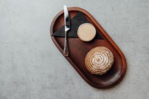 a wooden plate with a knife and a hat on it at The Dunes in Tenby