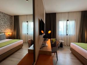 una camera d'albergo con due letti e uno specchio di Hotel Ben Batouta - Tanger a Tangeri