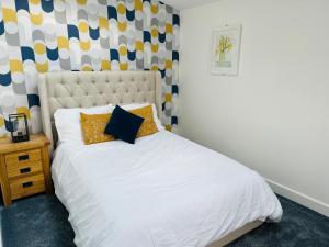 a bedroom with a white bed with yellow pillows at The Hayloft in Hernehill