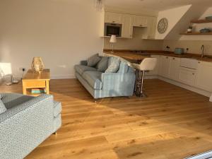 a living room with a couch and a kitchen at The Hayloft in Hernehill