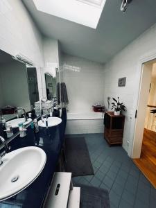 a bathroom with two sinks and a large mirror at Panoramahaus am Ammersee I Sauna I Wellness I Kamin in Herrsching am Ammersee +40 photos