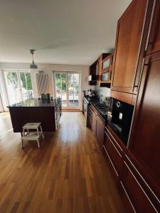 a kitchen with wooden cabinets and a wooden floor at Panoramahaus am Ammersee I Sauna I Wellness I Kamin in Herrsching am Ammersee