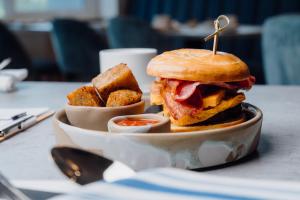 a sandwich on a plate on a table with some food at The Dunes in Tenby