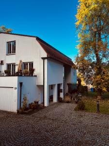a white house with a tree in front of it at Panoramahaus am Ammersee I Sauna I Wellness I Kamin in Herrsching am Ammersee