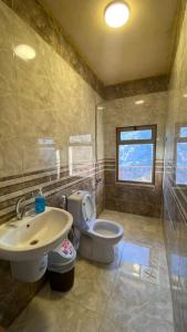 uma casa de banho com um WC branco e um lavatório. em Wild Dana Eco Lodge- Hotel-Eco-Camp em Dana
