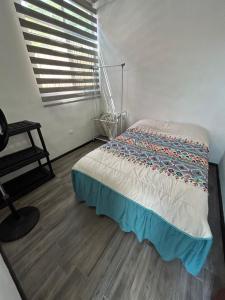 1 dormitorio con 1 cama en una habitación con ventana en Departamento Amueblado con Alberca Pedregal A, en Tamasopo