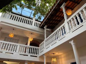 duży biały budynek z balkonem i żyrandolami w obiekcie Los Patios Hostel w mieście Cartagena de Indias