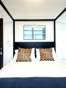 - une chambre avec un lit noir et blanc et une fenêtre dans l'établissement Stylish flat in North Kensington, à Londres