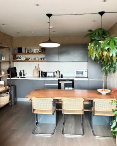 une cuisine avec une grande table et des chaises en bois dans l'établissement Stylish flat in North Kensington, à Londres