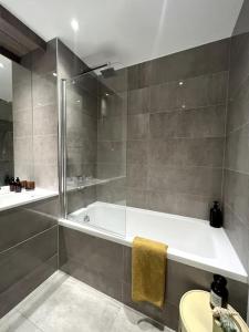 La salle de bains est pourvue d'une douche et d'une baignoire. dans l'établissement Stylish flat in North Kensington, à Londres