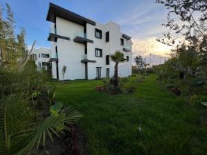 a white building in a field of green grass at Hotel Ben Batouta - Tanger in Tangier