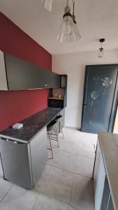 a kitchen with a black counter and a red wall at La Kay Sicrié studio de standing in Saint-Pierre