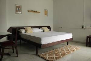 a bed in a room with a table and a chair at Noor Plaza in Angamali