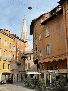 una calle de la ciudad con edificios y una torre del reloj en AS APartment Modena, en Módena