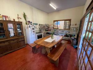 cocina con mesa de madera y nevera en Vila Amor - Charmosa e Central en Alto Paraíso de Goiás