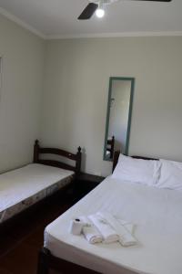 Dos camas en una habitación con toallas. en Camping Pousada Ilha do Mel - Frente ao Mar, en Boracéia