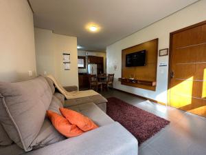 uma sala de estar com um sofá e uma televisão de ecrã plano em Apto Rua Coberta Gramado em Gramado