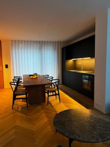 a dining room with a table and chairs and a kitchen at Boutique City Apartment Aarhus in Aarhus