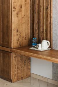 a wooden counter with a coffee maker and a telephone on it at Садиба Казка in Vizhenka