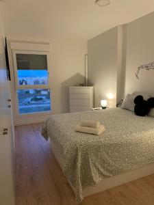 a bedroom with a bed with two towels on it at Hermoso apartamento in Valencia