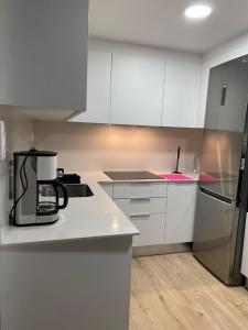 uma cozinha com armários brancos e um aparelho preto em Hermoso apartamento em Valência