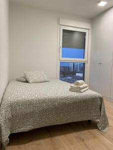 a white bedroom with a bed with a window at Hermoso apartamento in Valencia