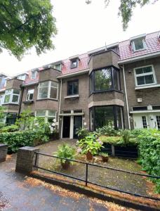 a large brick house with two potted plants in front of it at Nette maisonnette in groene rustige wijk in Rijswijk