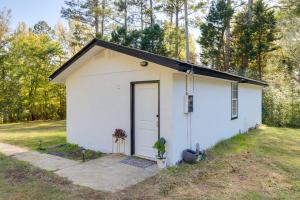 un petit hangar blanc avec une porte dans une cour dans l'établissement Fayetteville Guest House Walk to Nature Preserve!, à Fayetteville