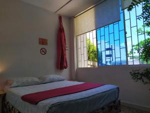 a bedroom with a bed and a window at Casa Almendros in Cartagena de Indias