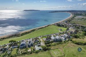 an aerial view of a beach with houses and the ocean at Seafeathers - Luxury Holiday Home with Sea Views in Overcombe