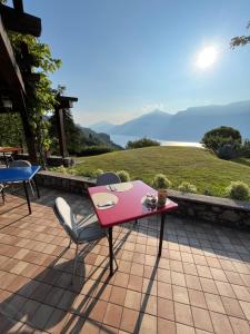 a pink table and chairs on a patio with a view at Villa Selene in Tremosine Sul Garda
