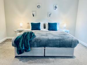 a bedroom with a large bed with blue pillows at Absolutely Beautiful Hemel Hempstead 2-bedroom for 1-5 Guests - contractors welcome in Hemel Hempstead