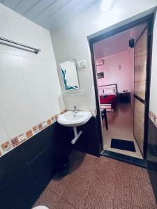 uma casa de banho com lavatório e chuveiro e um quarto em Blue Mirage Palolem Goa em Canacona