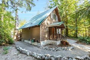 una piccola cabina in legno in mezzo al bosco di PNW River Cabin - A-Frame Loft Hot tub & firepit. 