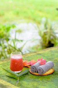a glass of watermelon juice and a pair of towels at Paddy Field View Resort in Mirissa