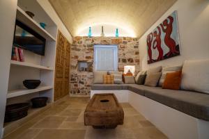 un soggiorno con divano e tavolo di trullo la specchia private pool and satellite wifi a San Michele Salentino
