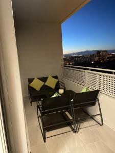 un balcone con 2 sedie, un tavolo e una finestra di Hermoso apartamento a Valencia