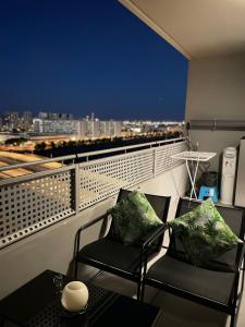 a balcony with two chairs and a view of a city at Hermoso apartamento in Valencia