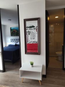 Zimmer mit einem Bett und einem Bild an der Wand in der Unterkunft Apartamento céntrico en Manizales, costo por noche $125.000 in Manizales