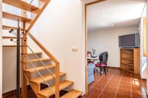 a staircase in a room with a table and a television at Casa da Eira in Tondela