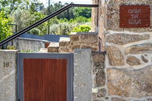 a stone building with a door and a sign on it at Casa da Eira in Tondela