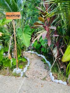 um sinal no meio de um jardim com plantas em Jaakbal Tulum em Tulum