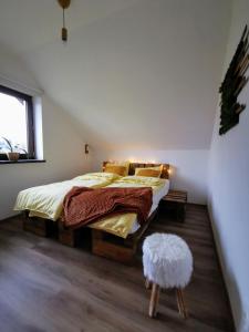 a bedroom with a bed and a stool in it at Rodinná Rezidence Žihobce - prázdninový dům in Žihobce