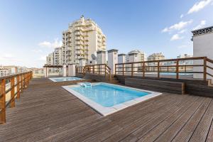 a rooftop deck with two swimming pools on a building at Dream Nest in Armação de Pêra