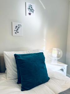 a blue pillow sitting on top of a bed at Absolutely Beautiful Hemel Hempstead 2-bedroom for 1-4 Guests - contractors welcome in Hemel Hempstead