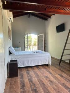 sypialnia z dużym łóżkiem i oknem w obiekcie Camping Pousada Ilha do Mel - Frente ao Mar w mieście Boracéia