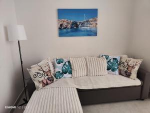 a couch with pillows on it in a room at Lilly's Sea view, beachfront apartment in Marsalforn