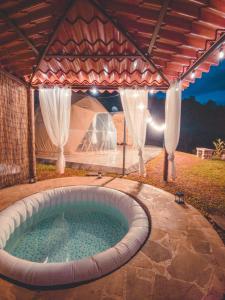 a hot tub in a backyard with a tent at Las Colinas Glamping in Turrialba