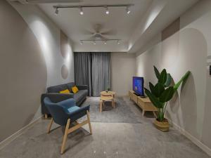 een woonkamer met een bank en een tv bij The Ooak Suites @ 163 Building (Mont Kiara) in Kuala Lumpur