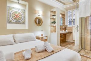 una camera da letto con un grande letto bianco e un bagno di Easybnb - Domus Orbitelli a Roma